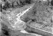 1 vue Tête amont de la deuxième digue de dérivation réparée et protégée par un barrage, un revêtement surmonté d'un lit de gabions, vue d'aval vers l'amont