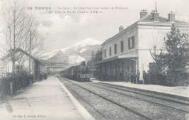 1 vue  - La gare. Arrivée d\'un train venant de Briançon. Au fond : le pic du Clocher (2456 m)Lib. Pap. L. Goujon, Embrun (ouvre la visionneuse)